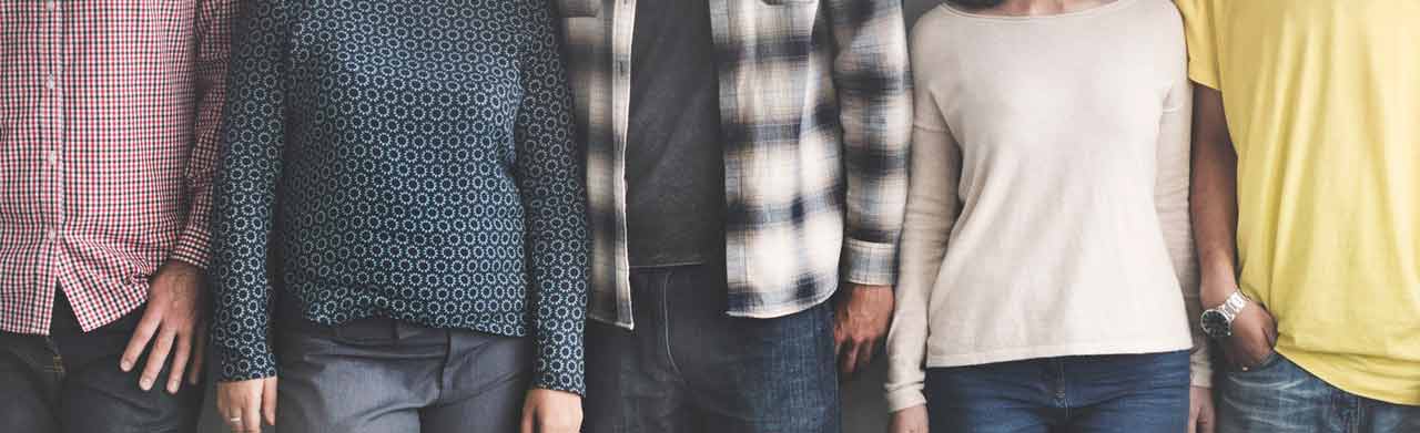 hero image of 5 people standing with shoulders touching, image is cropped without faces or feet